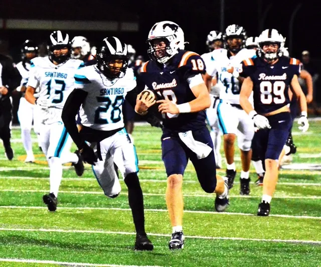 Santiago’s Ammon Warner (13) and Calvin Sneed (28) chase Roosevelt QB Charlie Bohmer (18) as he scampers on a 45-yard gain during the Mustangs 35 – 0 shutout of the Sharks. Credit: Photo by Gary Evans