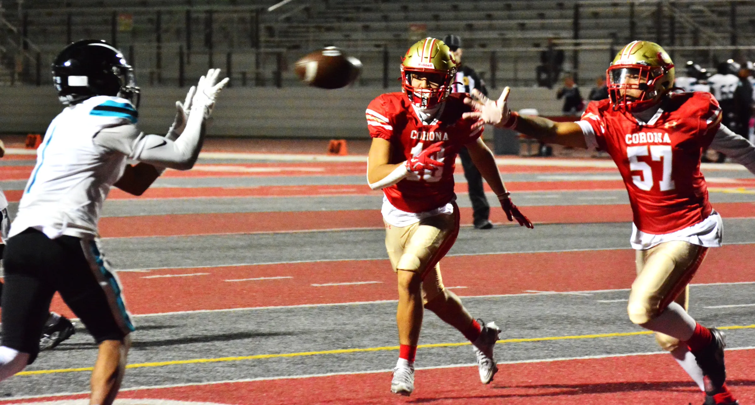 Santiago receiver Isaiah Hughes (left) hauls in a pass from QB Jake Wilson while Corona defenders Josiah Sapien (18) and Damian Bugarin (57) look on. Credit: Photo by Gary Evans