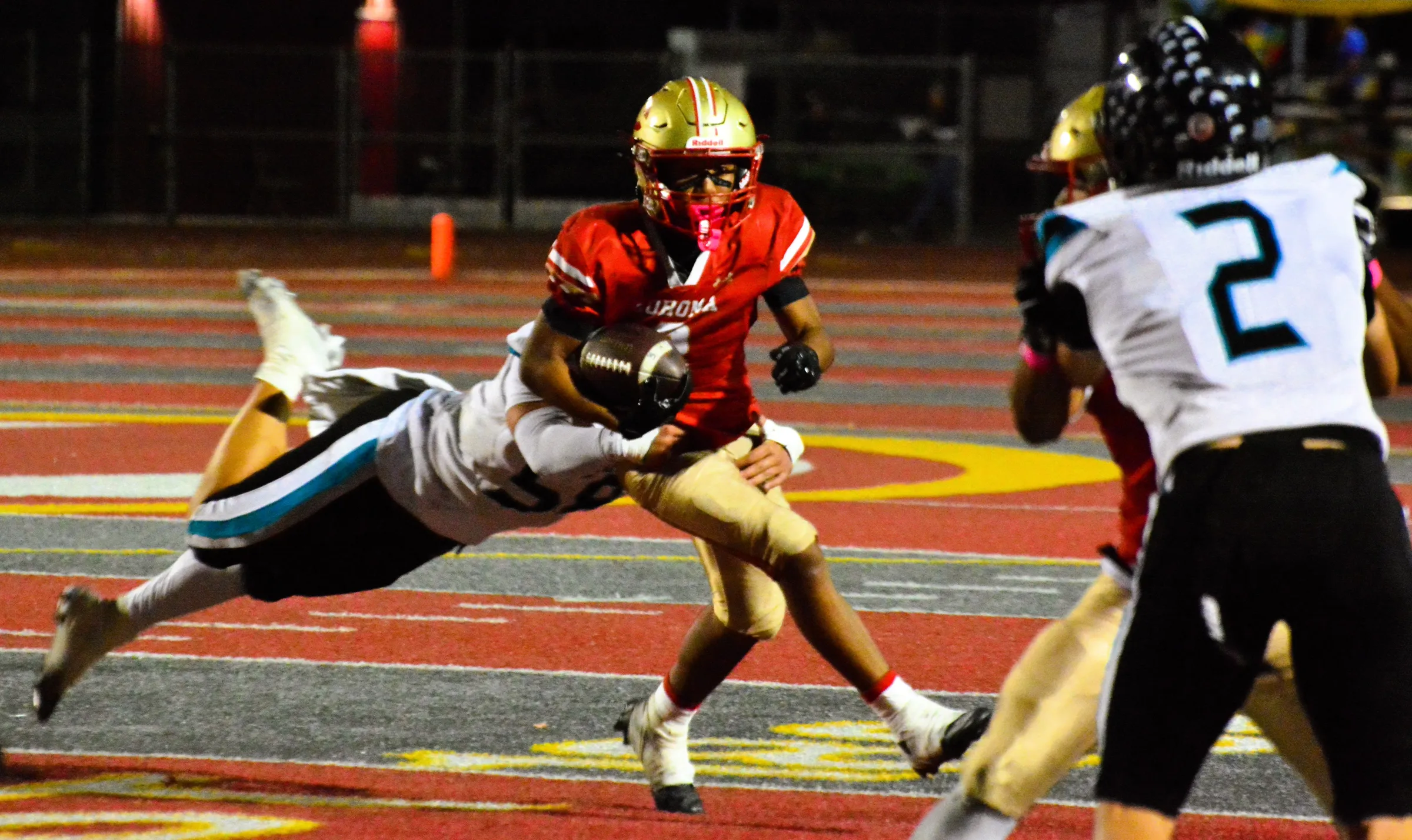 Santiago’s Chad McMaster (left) makes a flying tackle of Corona’s Benjamin Campusano (center) as a Panther blocks Jack Talley (2). Credit: Photo by Gary Evans