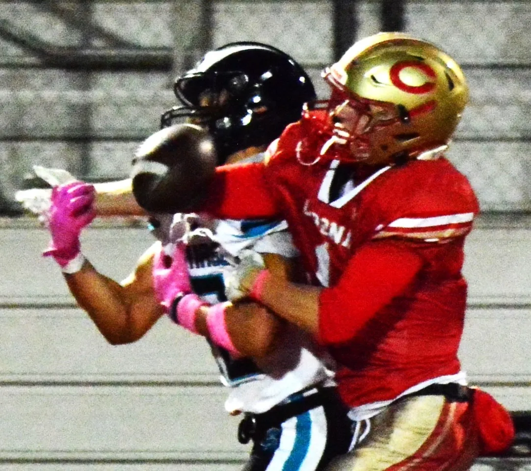 Santiago’s Carter Ward (left) gets hit by Corona’s Dayton McNeil (right) while attempting to catch a 2nd-quarter pass.  A penalty was called on McNeil.  The Sharks scored two second-half touchdowns to beat the Panthers 14 – 0. Credit: Photo by Gary Evans