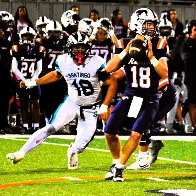 Santiago defender Max Eldridge (18) bears down on Roosevelt QB Charlie Bohmer (18) during the first quarter, but Bohmer got the pass away, avoiding the sack. Credit: Photo by Gary Evans